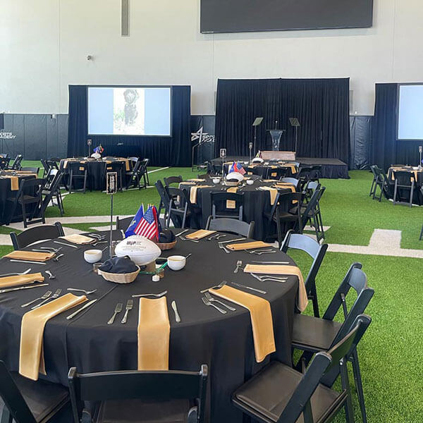 Large banquet room in Dallas, TX, with tables and chairs organized for a corporate event planning occasion