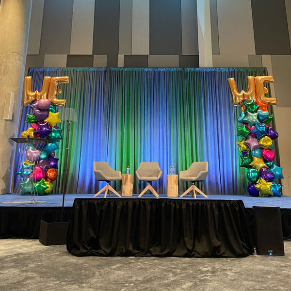 Staging in Dallas, TX, showcasing a vibrant banner decorated with balloons for an upcoming event